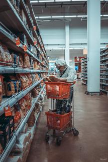 woman standing near shopping cart by Vlad Frolov courtesy of Unsplash.