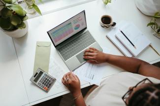 a person sitting at a table with a laptop by Microsoft 365 courtesy of Unsplash.