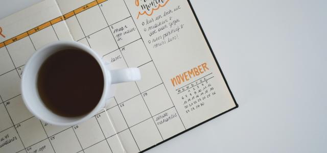 white ceramic mug with coffee on top of a planner by Estée Janssens courtesy of Unsplash.